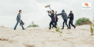 Jobs in media studies. Cinematographer on beach shooting a scene